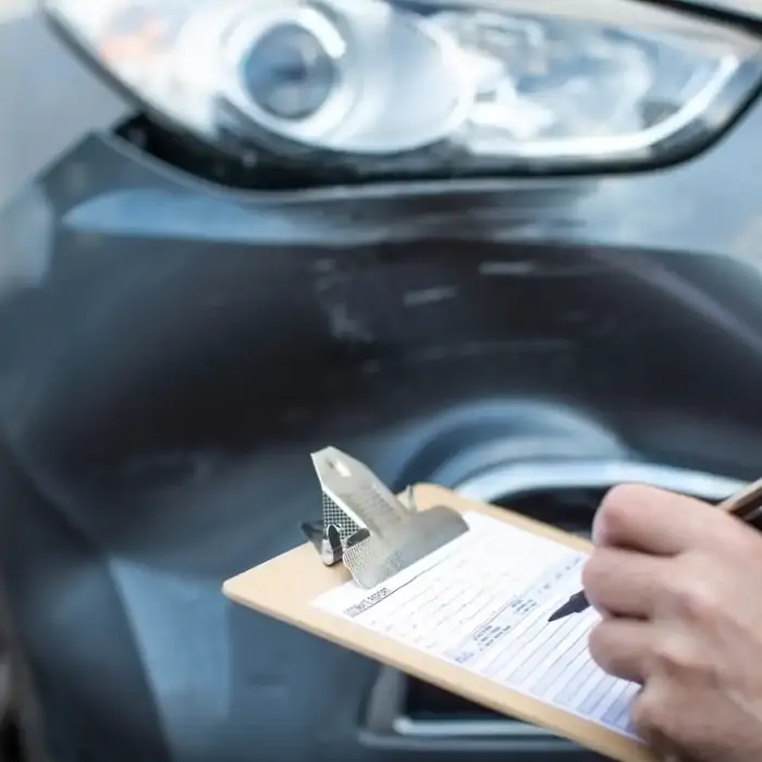 Technician inspecting a vehicle panel before dent repair