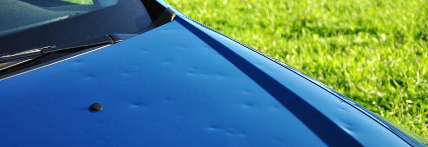 Hail dents visible on a vehicle body panel